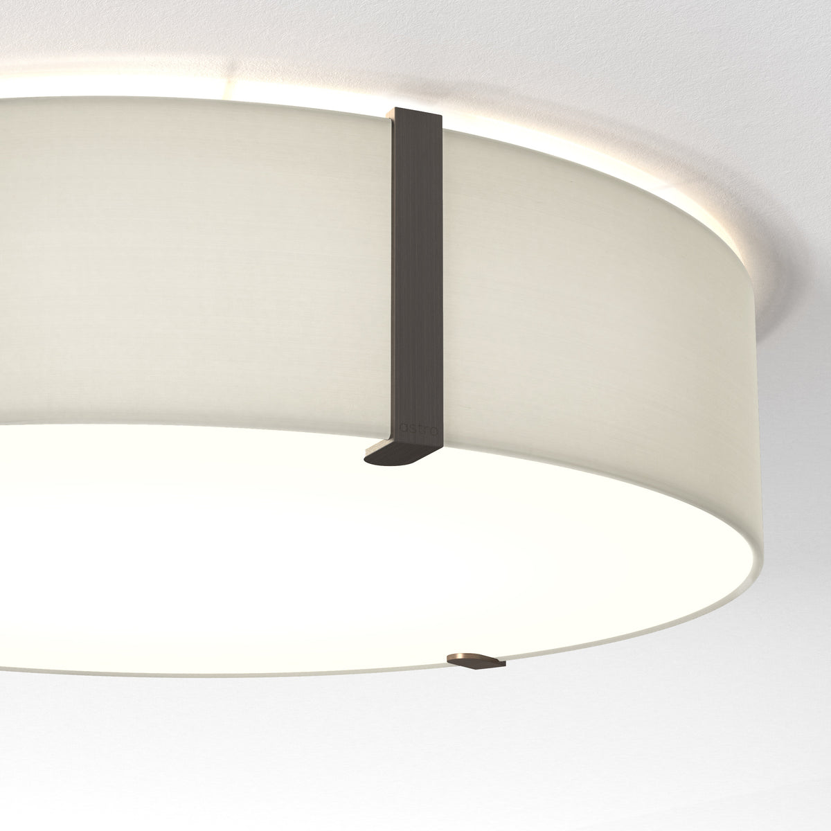 A close-up of a ceiling light fixture with a white fabric shade and dark metal accents