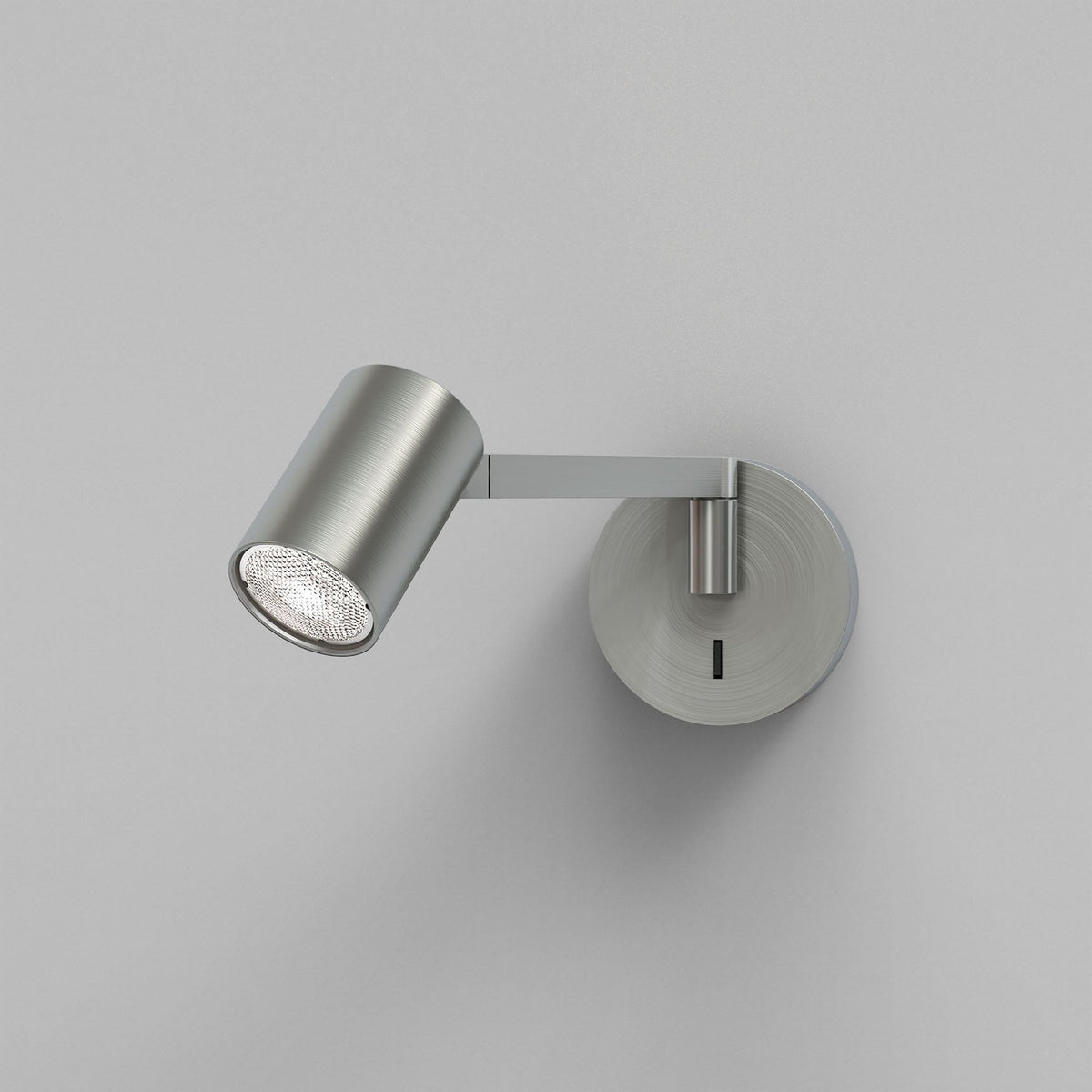 Brushed metal wall-mounted spotlight with a cylindrical head and a round base