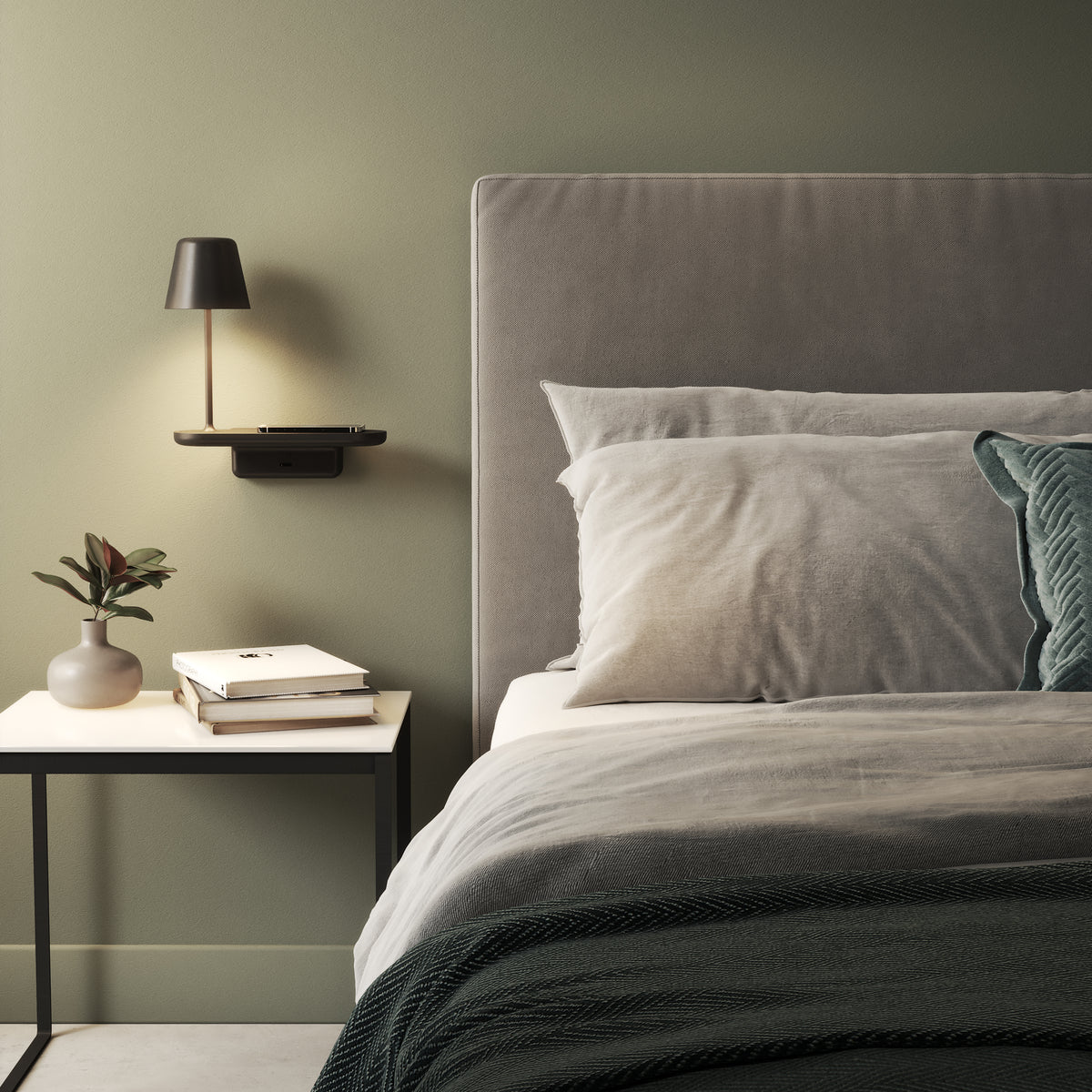 Bedroom with green walls, a grey upholstered headboard, and a side table with books and a vase