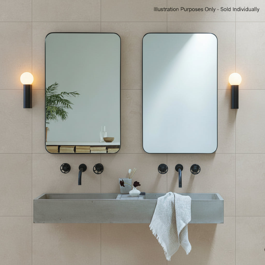 Two rectangular mirrors with black frames above a concrete trough sink with black wall-mounted faucets