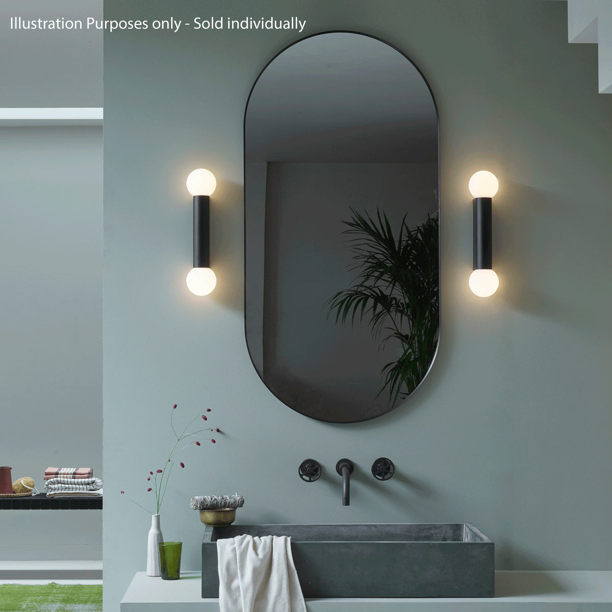 Oval mirror with two vertical wall lights, concrete sink, and dark faucet against a green wall