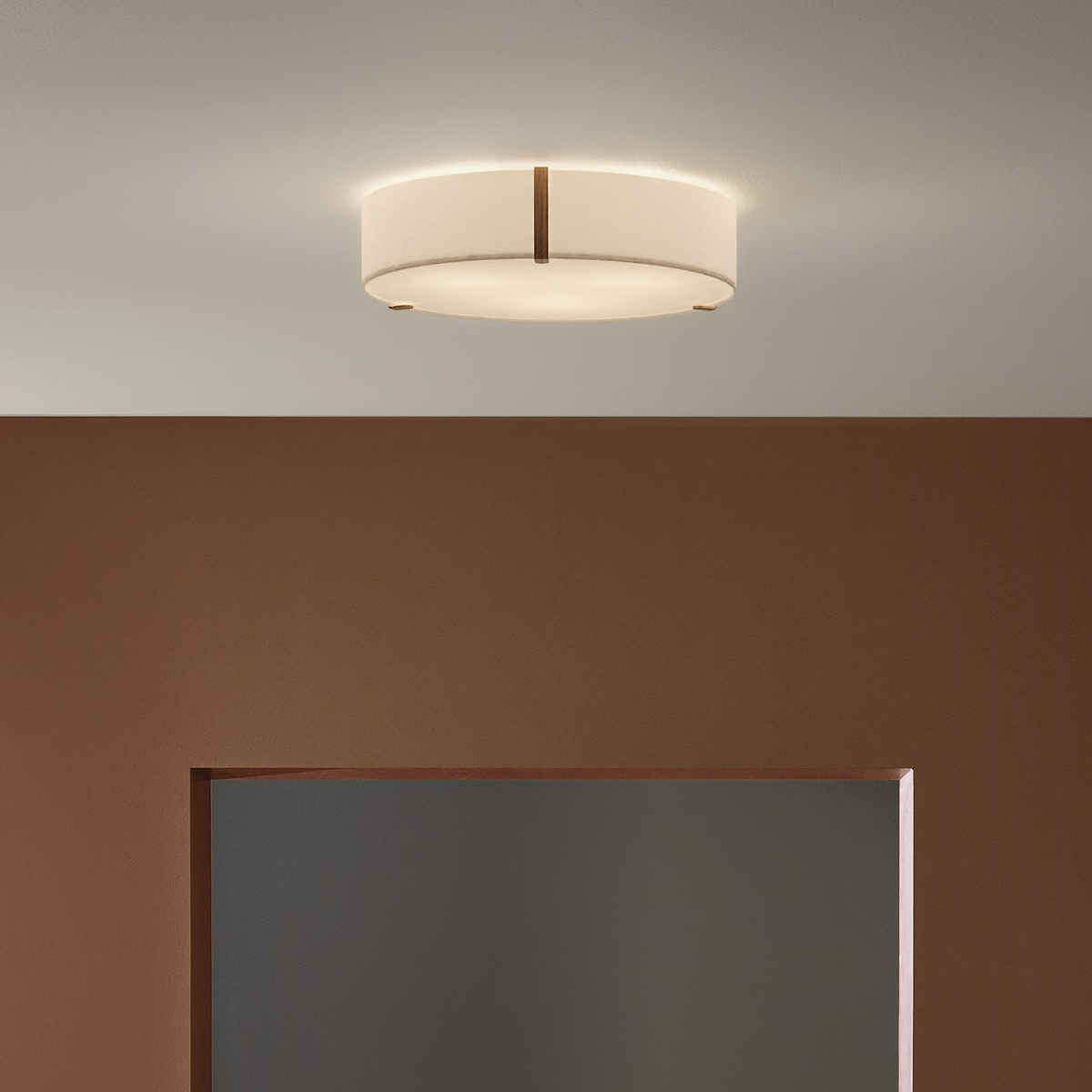 Round ceiling light fixture with a white fabric shade and wooden accents