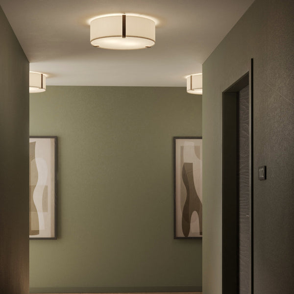 Hallway with olive green walls, two framed abstract art pieces, and ceiling lights