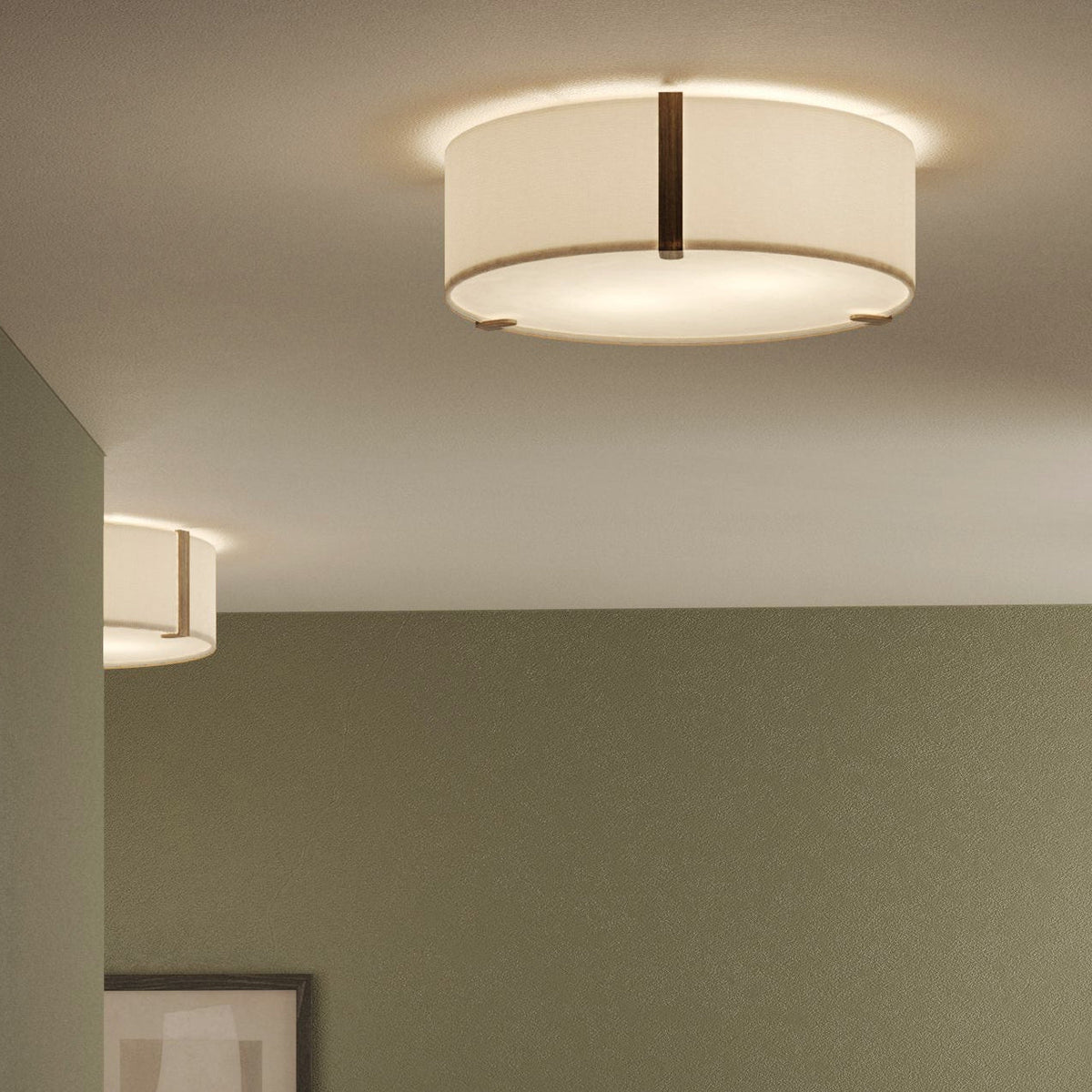 Two ceiling lights with drum shades and dark wood accents
