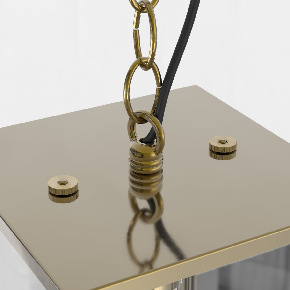 Close-up of a gold chain and black cord attached to a gold square base with two gold screws