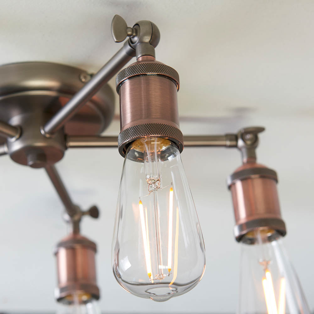 A close-up of an exposed bulb and bronze fitting on a semi-flush ceiling light.