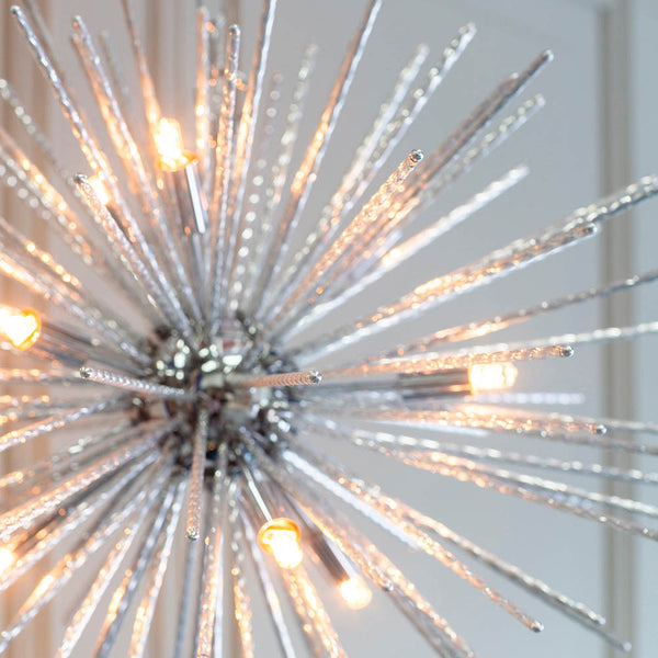 Close-up of a chrome Sputnik chandelier with clear glass rods, showing the illuminated bulbs and textured glass.