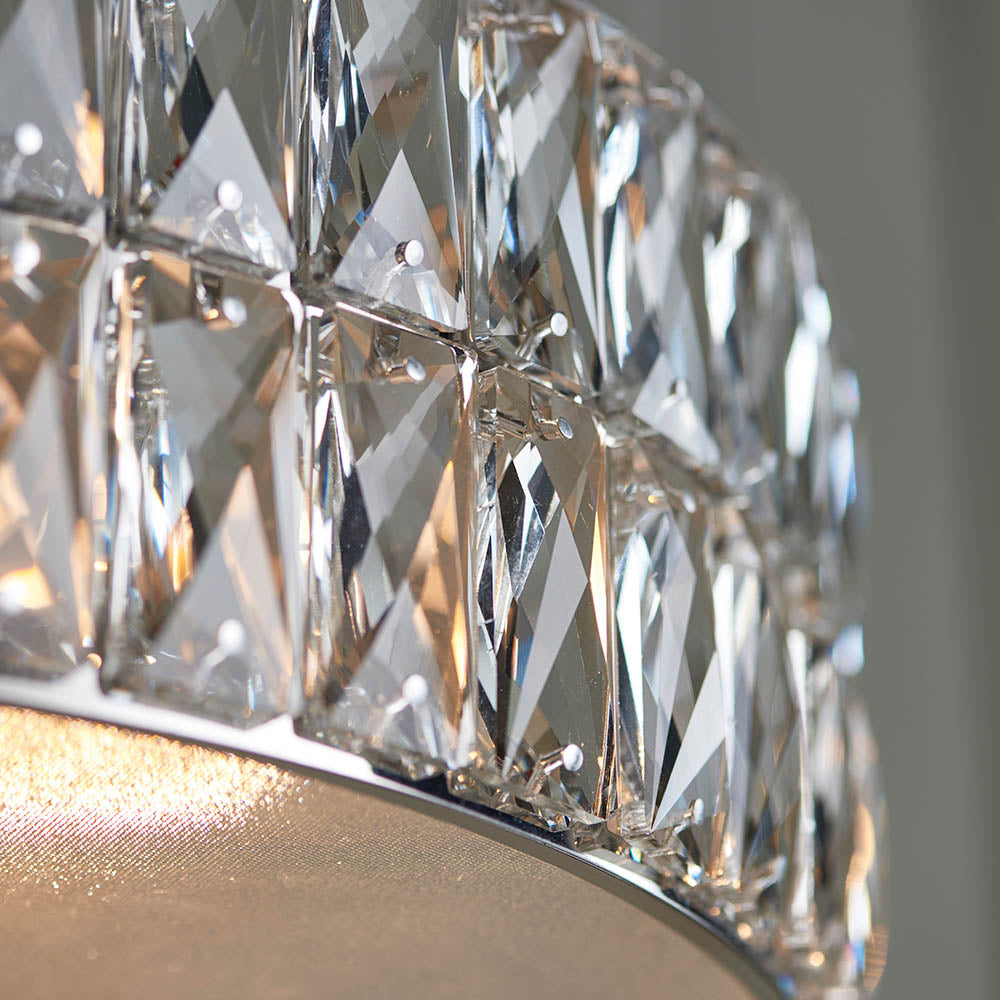 A detailed view of the rectangular crystals on the two-tiered chandelier, with light reflecting below.