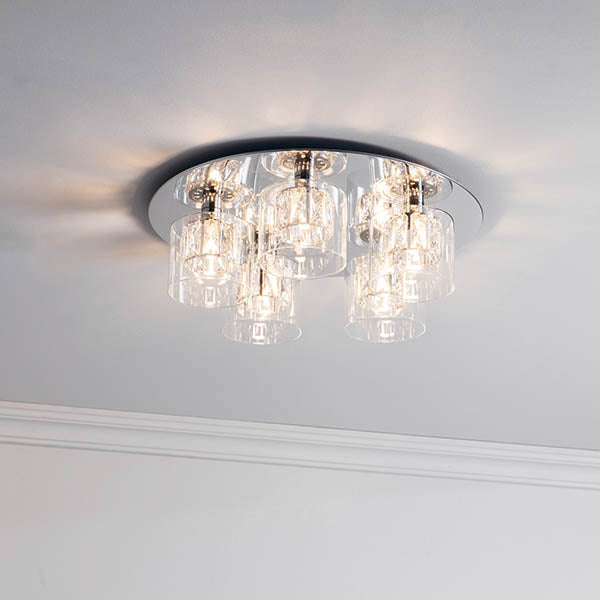 A chrome and crystal ceiling light with five clear glass shades on a white ceiling.