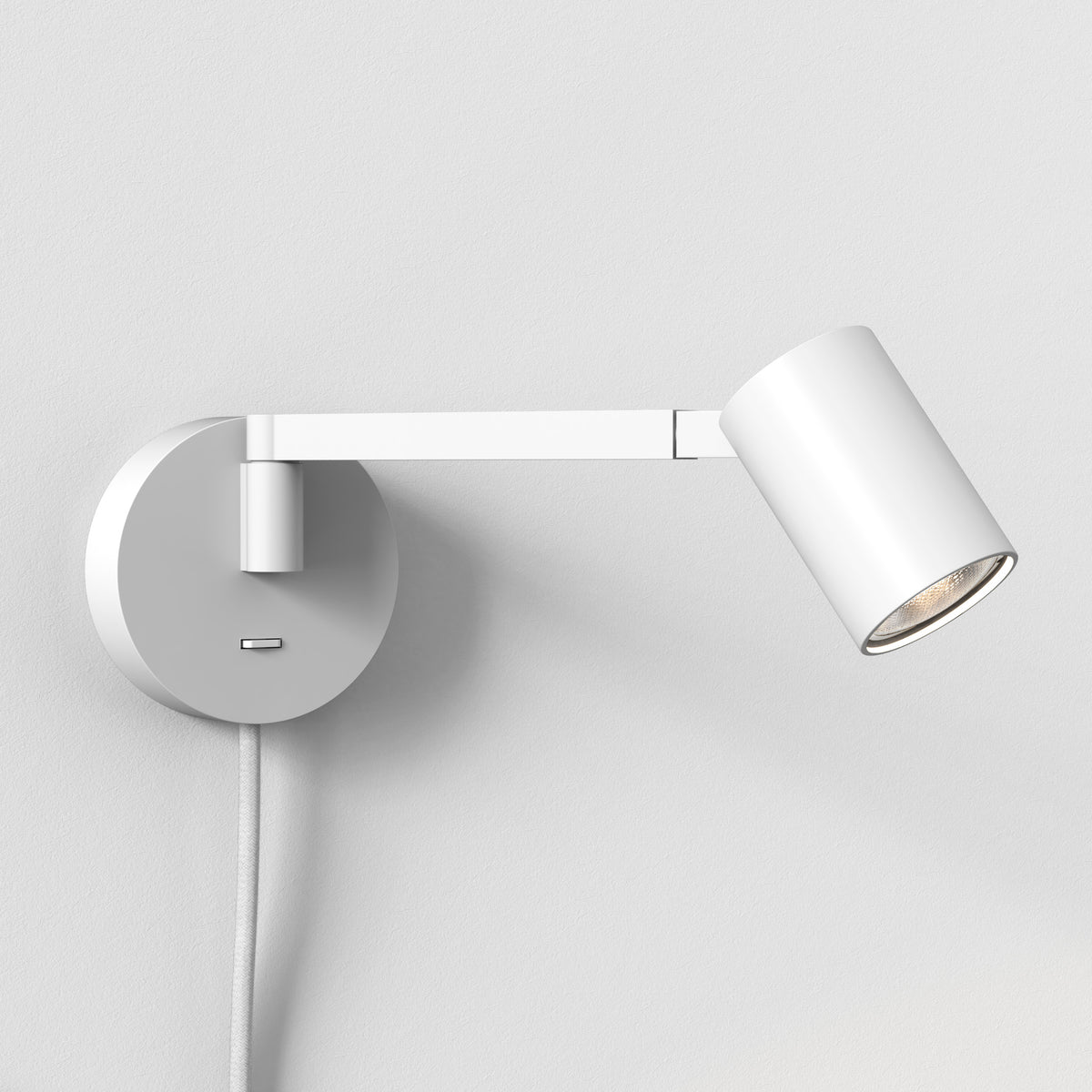 White wall-mounted spotlight with an adjustable arm and a visible lightbulb