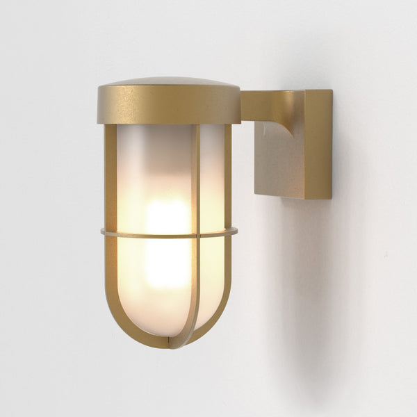 Brass wall light with a frosted glass shade and a protective cage