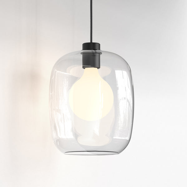 Clear glass pendant light with a black top and a glowing white bulb