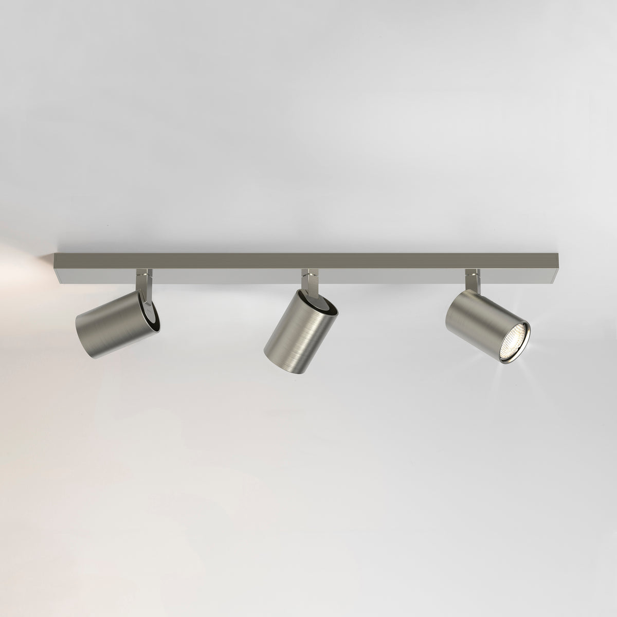 Three brushed nickel track lights on a white ceiling