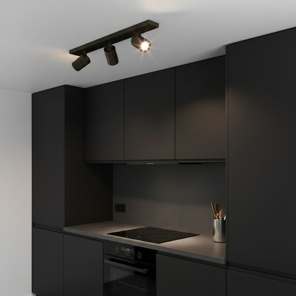 Black kitchen with track lighting, dark cabinets, and a built-in oven and stovetop