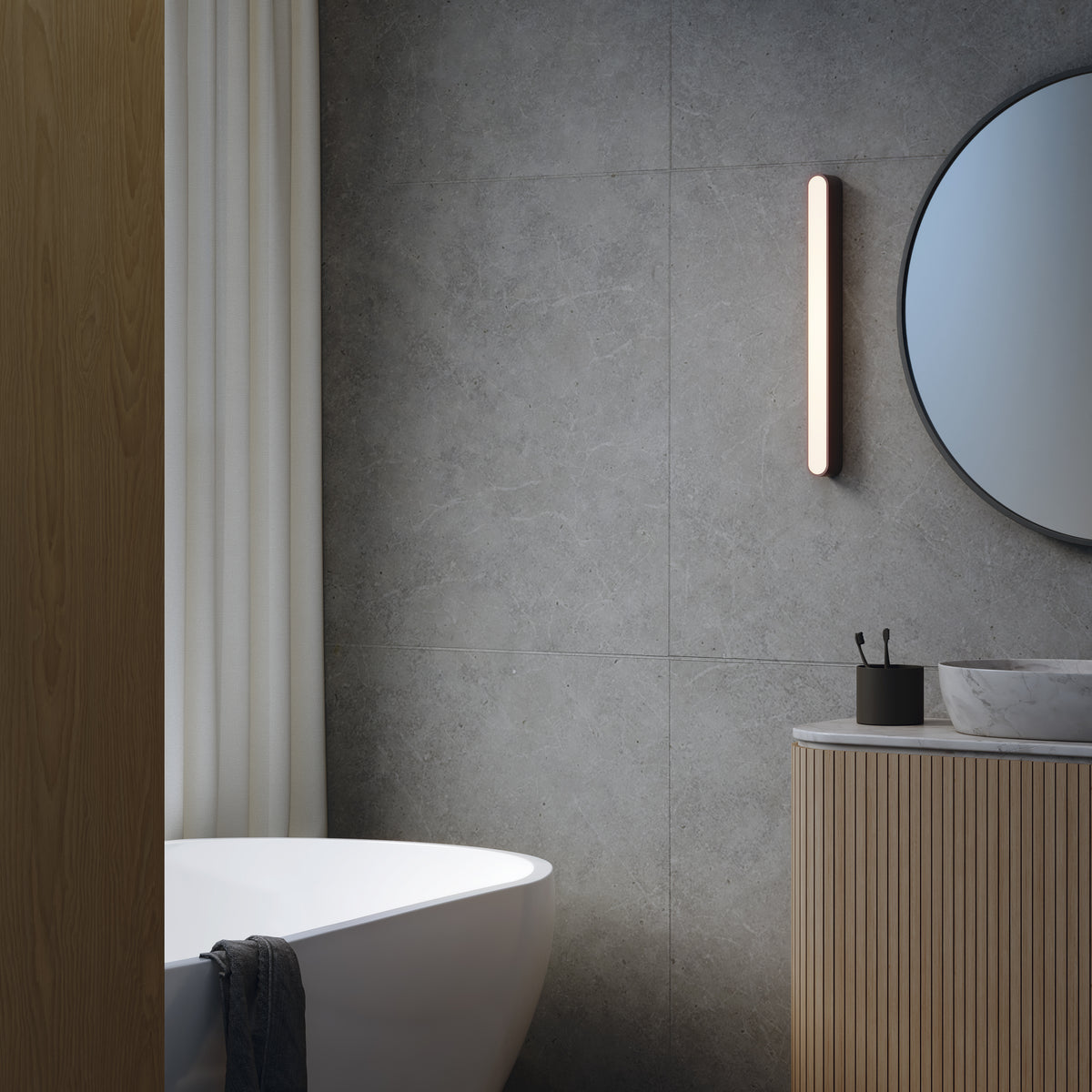 Modern bathroom with a white freestanding tub, a round mirror, and a wooden vanity with a marble sink