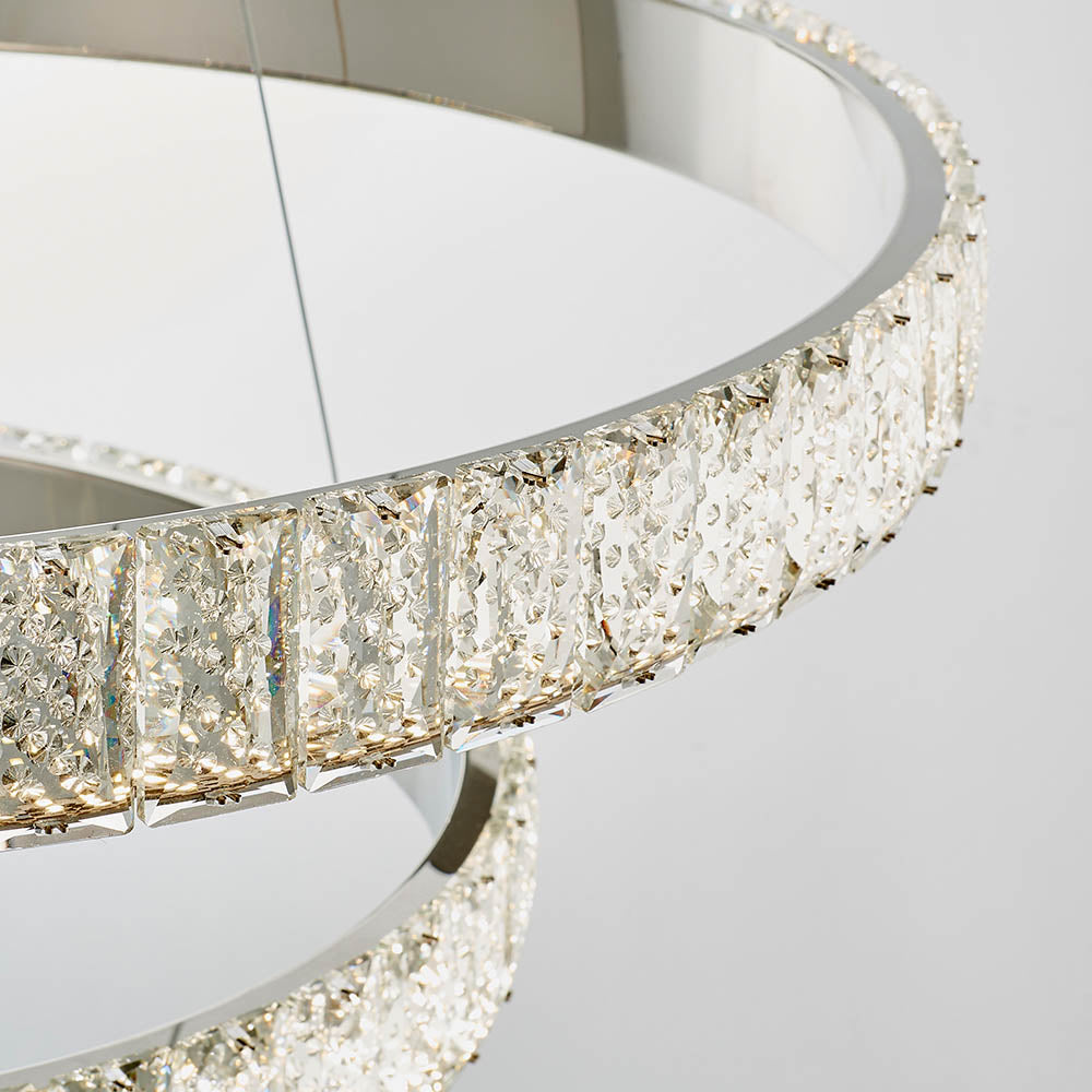 Close-up of the textured crystal and polished chrome of a ring chandelier.