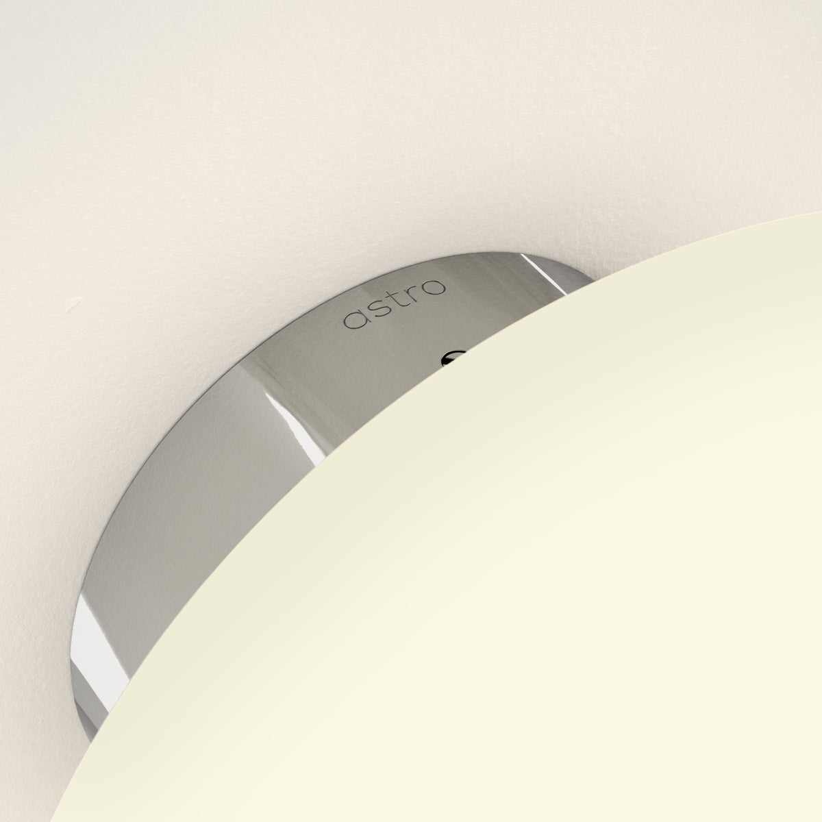 Astro logo on a metallic surface, partially obscured by a cream-colored curved object