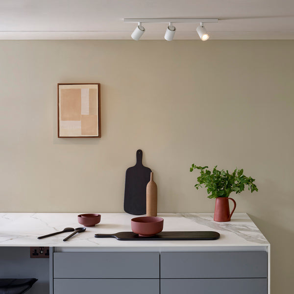 Kitchen counter with marble top, grey cabinets, and track lighting