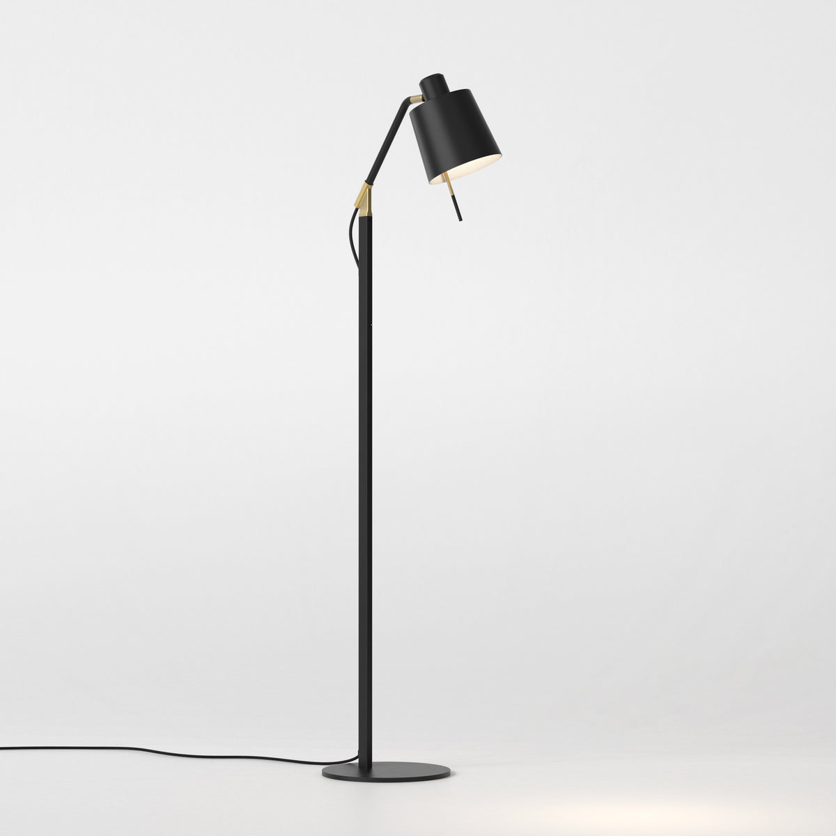 Black floor lamp with a gold adjustable arm and a round base