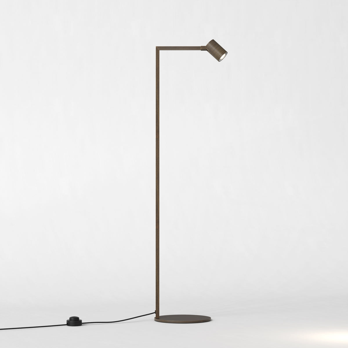 Bronze floor lamp with a thin vertical stand and a small, adjustable light head pointing downwards