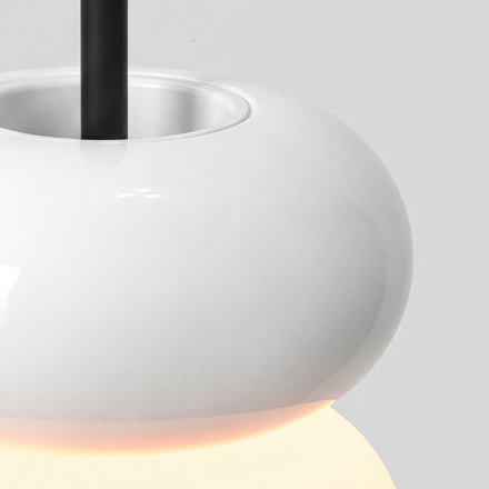 Close up of a white pendant light with a black rod and a glowing bottom