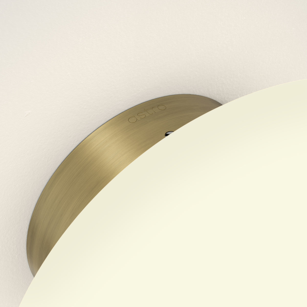 Astro logo on a curved brass plate, partially covered by a cream-colored curved surface
