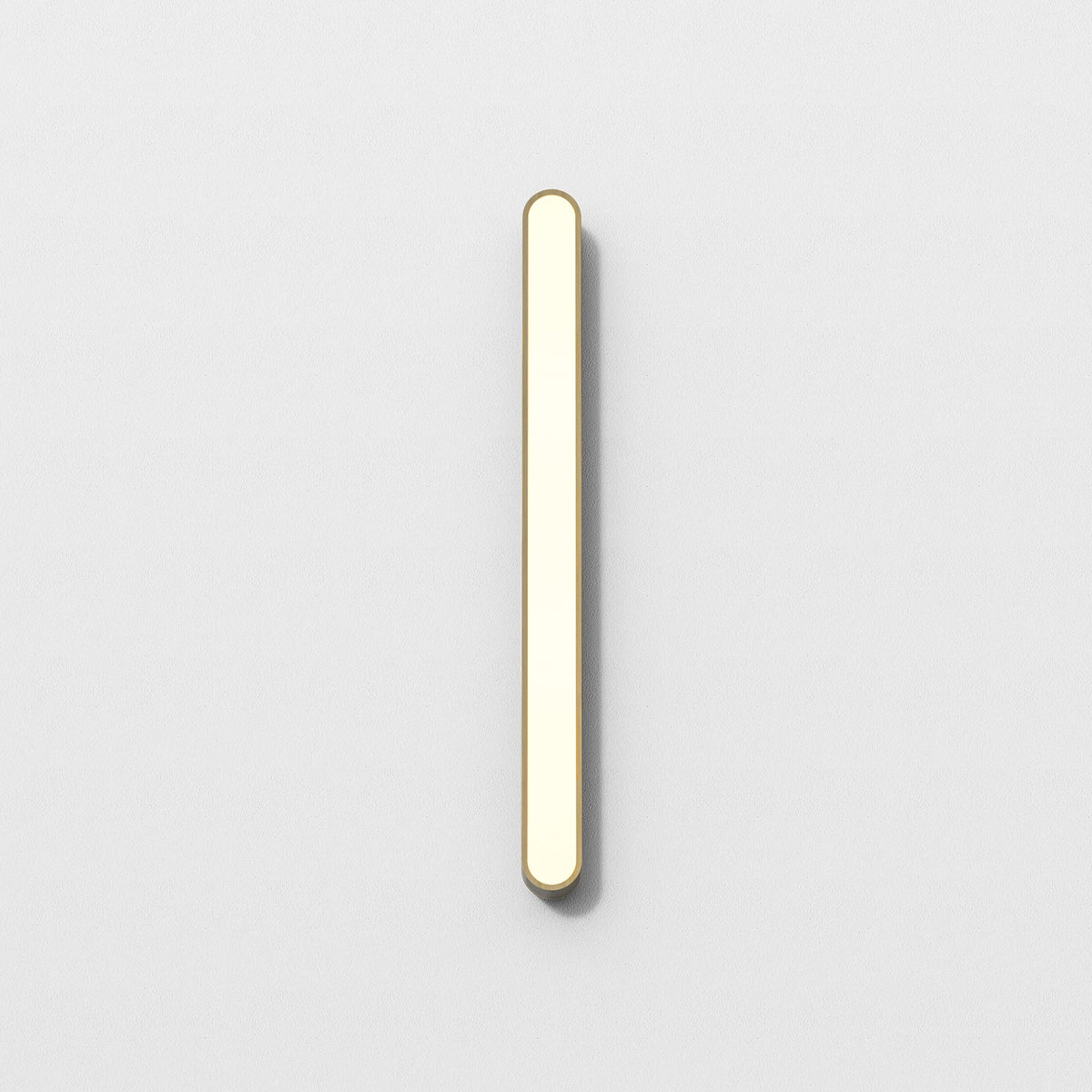Vertical gold and white light fixture on a white wall