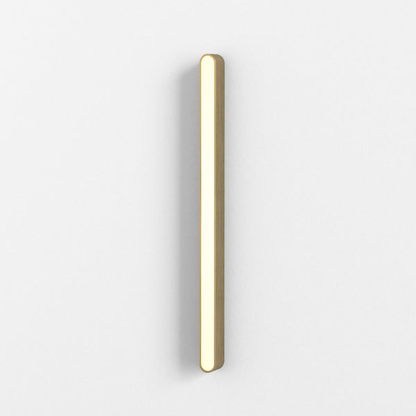 Vertical wooden light fixture with rounded ends, emitting a warm glow on a white wall