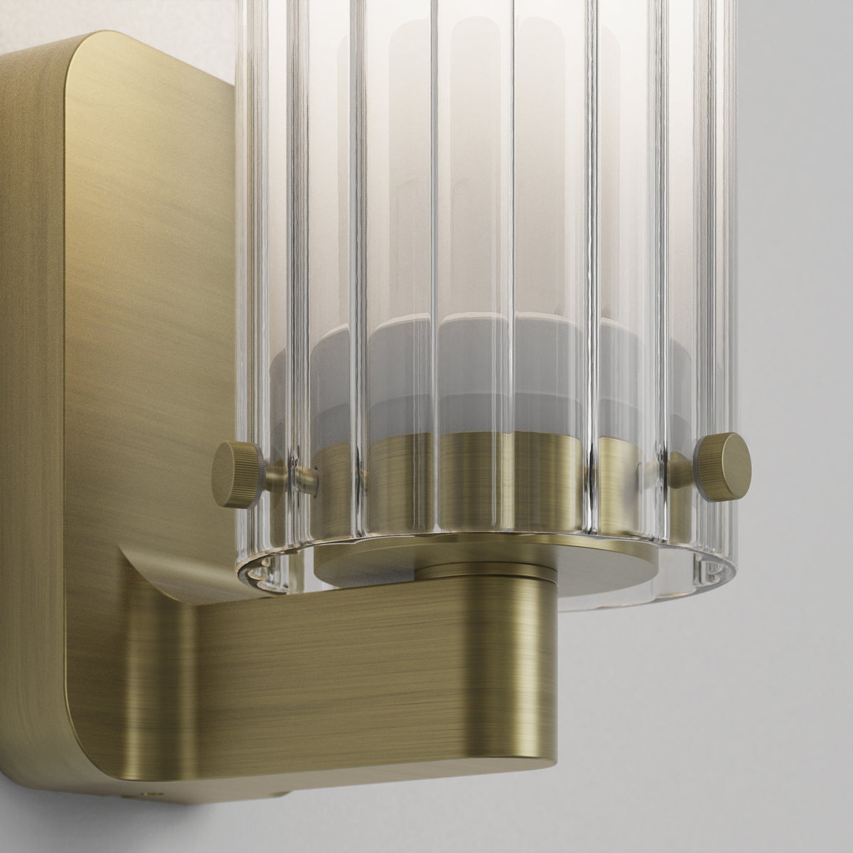 Close up of a brass wall light with a fluted glass shade
