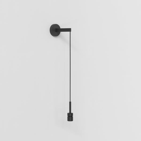 Black wall light with a round base and a long cord ending in a cylindrical bulb holder