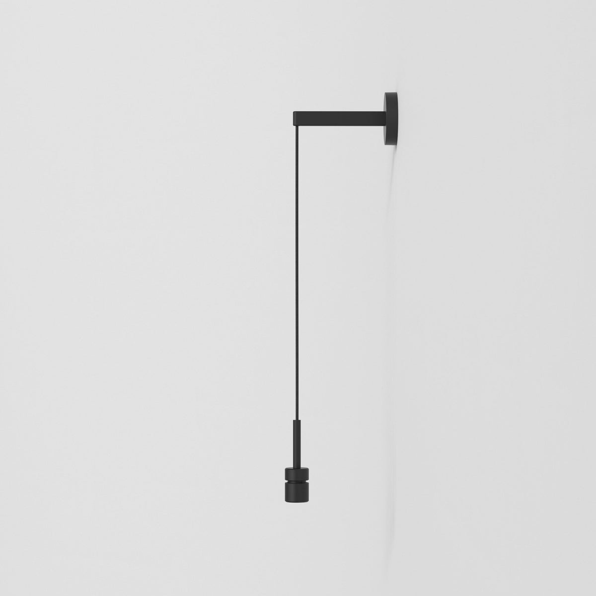 Black wall-mounted light fixture with a hanging cord and cylindrical pull switch