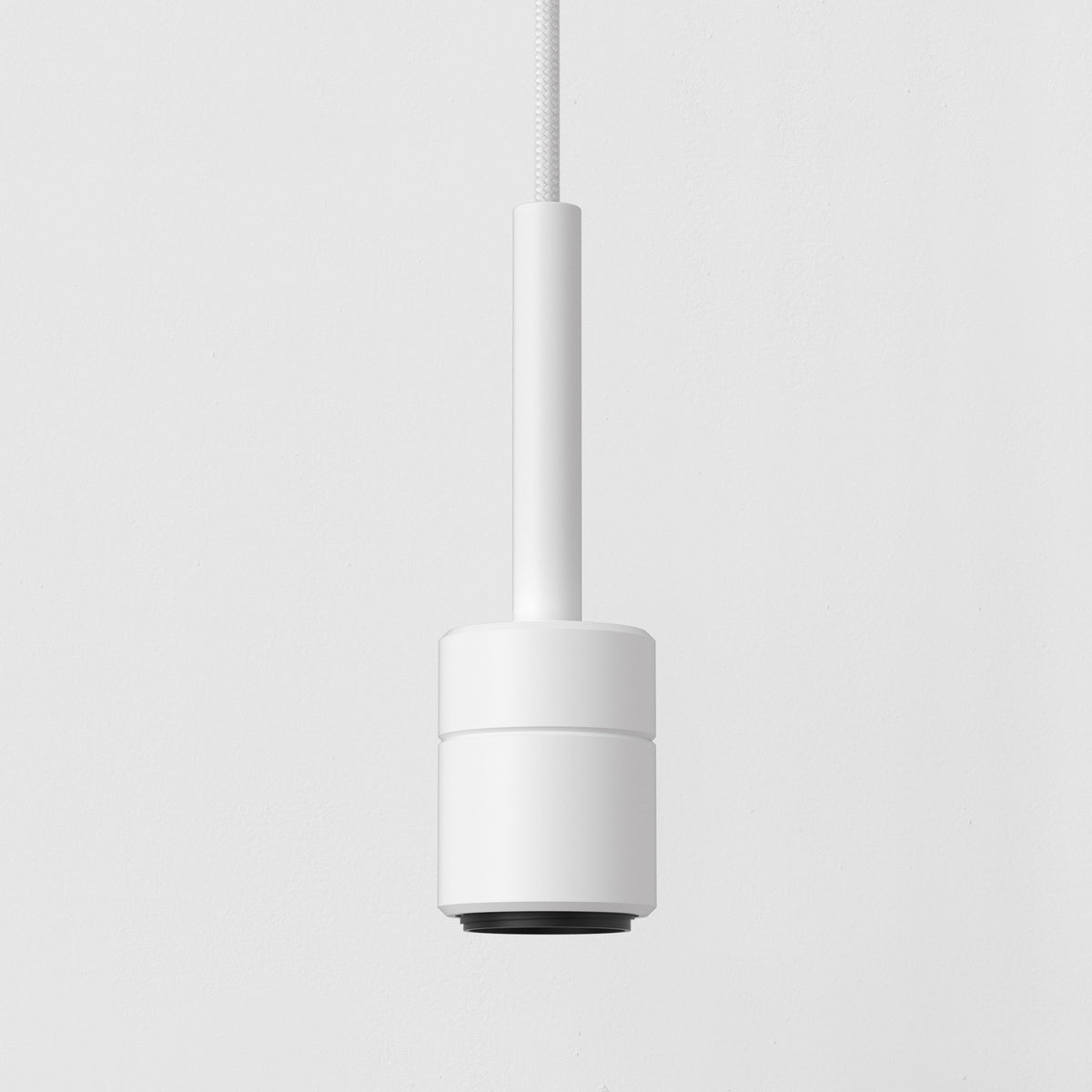 White cylindrical pendant light with a black base, hanging from a white braided cord against a white wall