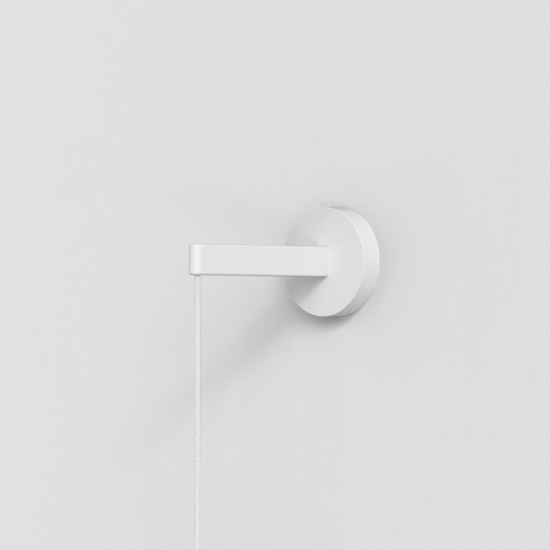 White wall mounted light fixture with a pull cord