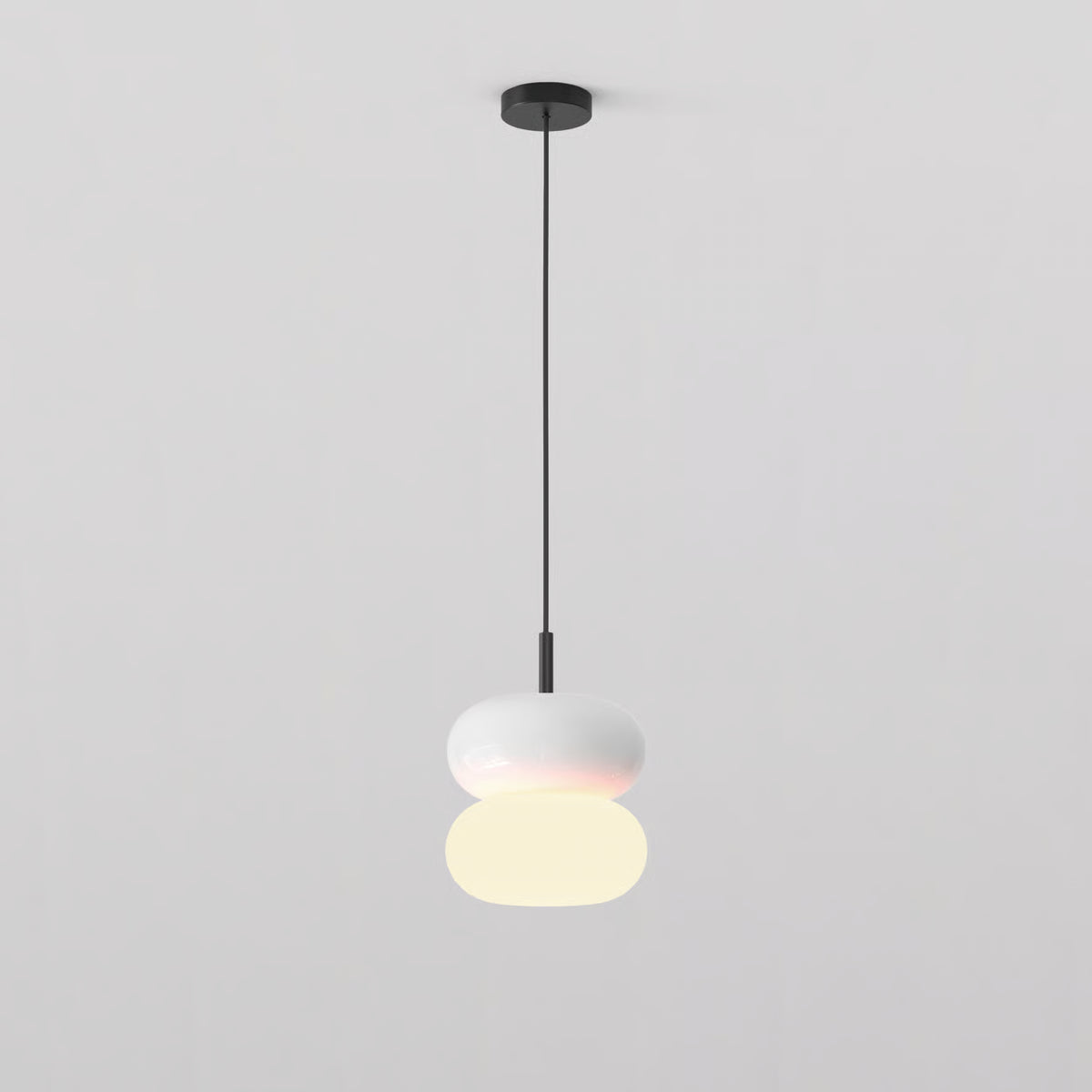 White pendant light with two stacked oval shades, the bottom one illuminated