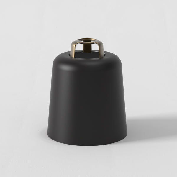 Black bell-shaped object with a brass handle on a white background