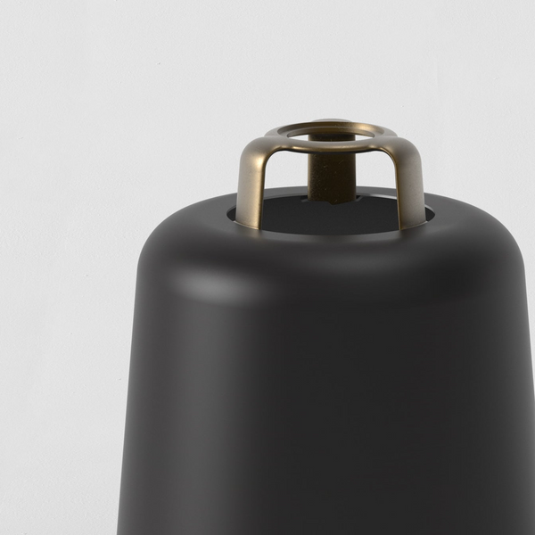 Close up of a black lamp with a brass handle