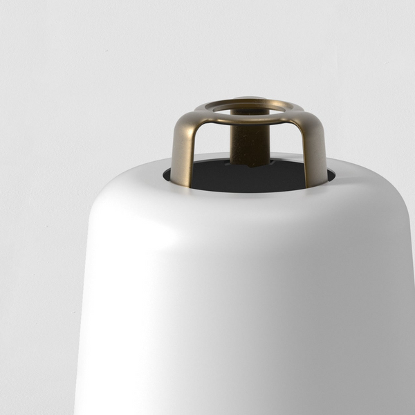 Top of a white lamp with a brass-colored metal ring detail