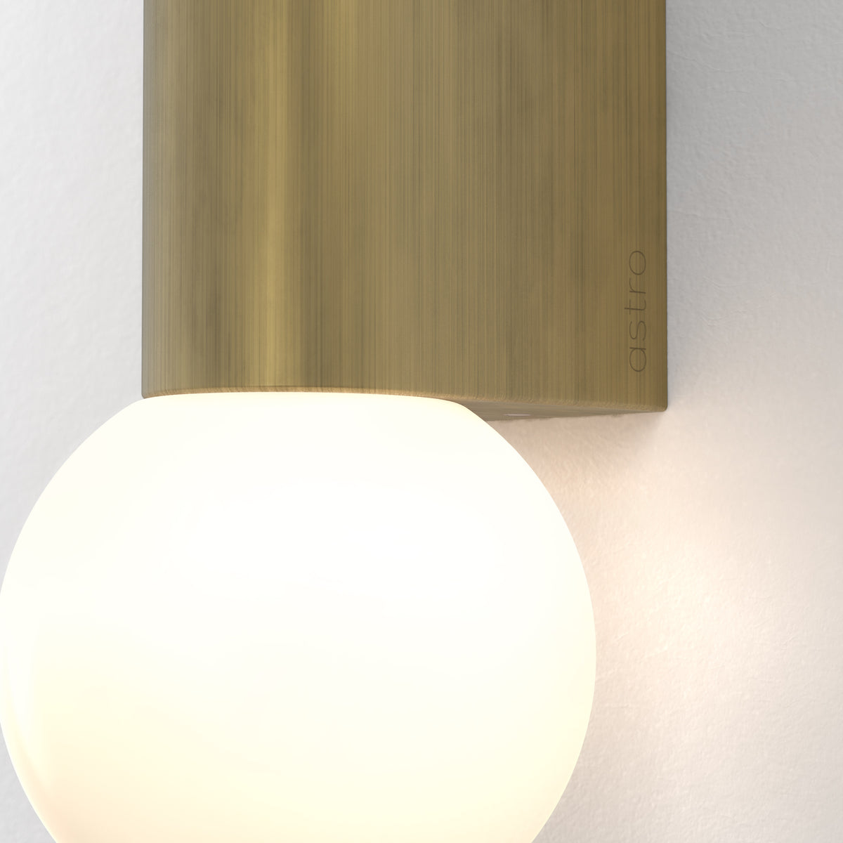 Astro branded wall light with a brushed bronze rectangular base and a large spherical white glass shade