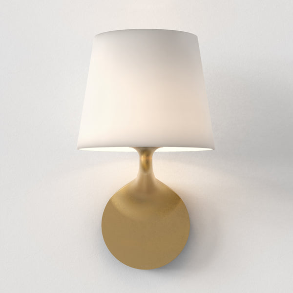 White fabric shade with a brass wall mount
