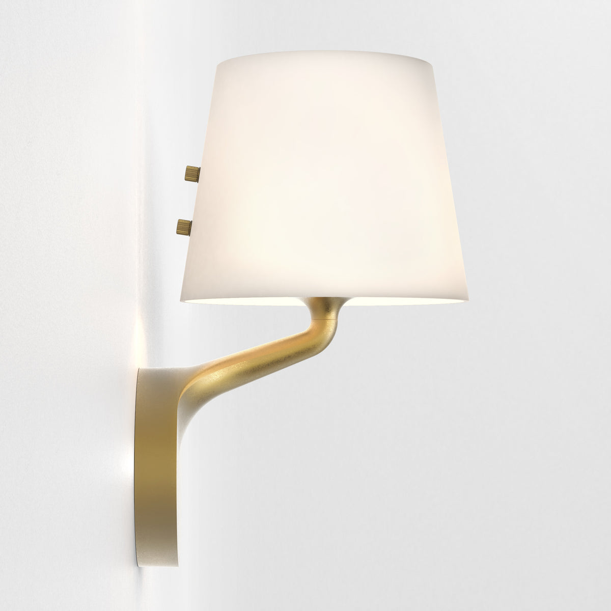 Brass wall lamp with a white conical shade and two small brass knobs on the side