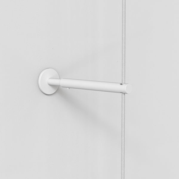 White wall mount with a horizontal bar holding a braided white cable