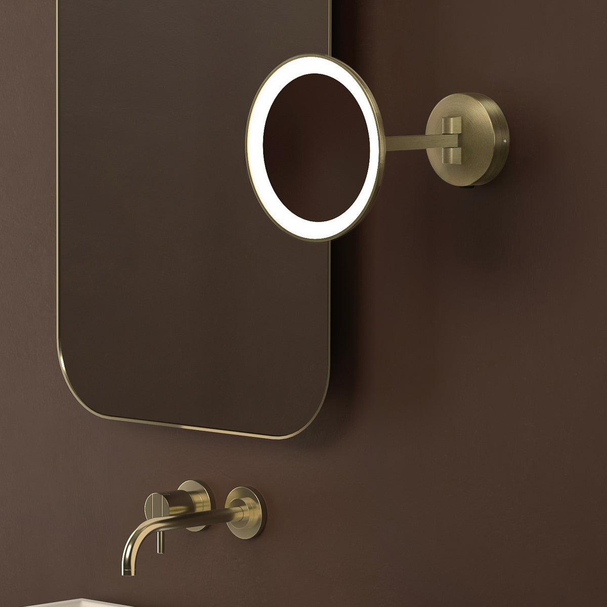 Wall-mounted gold faucet and mirror with a magnifying mirror attached