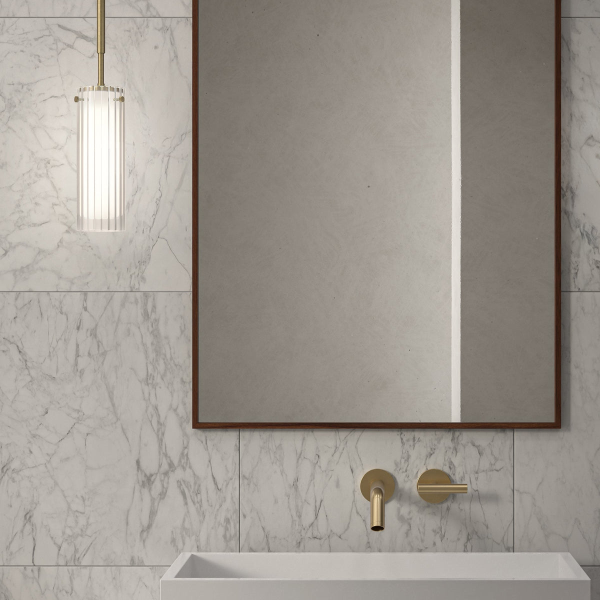 Bathroom with white marble walls, a rectangular mirror, a white sink, and gold faucet and light fixture