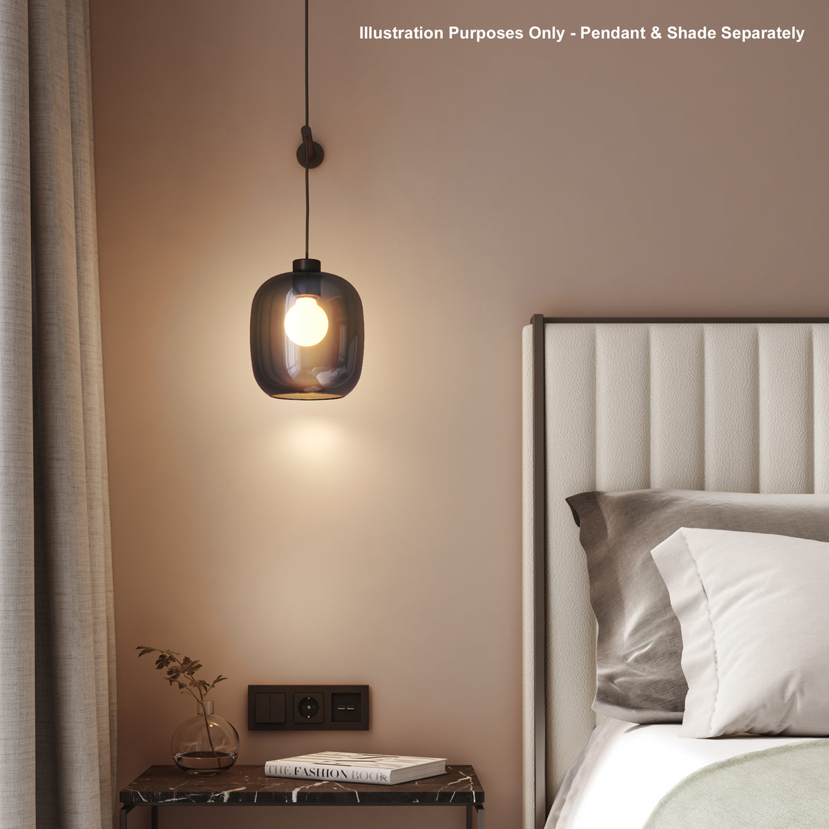 Pendant light with a dark glass shade and a glowing bulb, hanging next to a bed with a white headboard