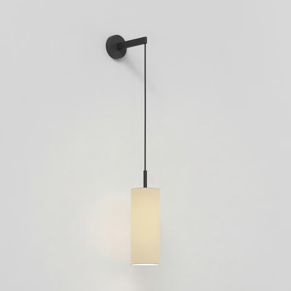 Black wall-mounted light fixture with a long, thin black cord and a cylindrical cream-colored shade