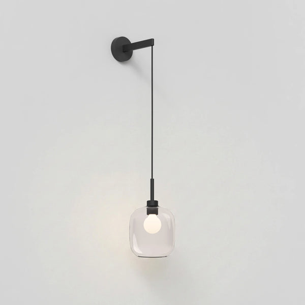 Black wall sconce with a clear glass shade and exposed bulb