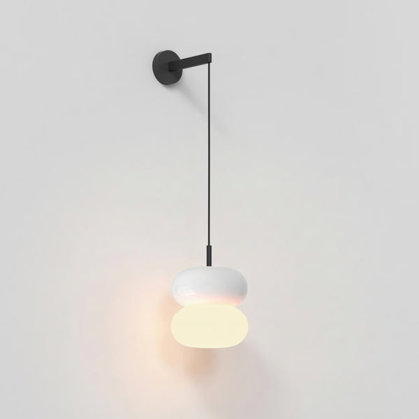 White wall light with two stacked oval shades, the bottom one illuminated, hanging from a black wall mount