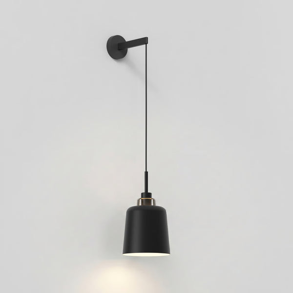 Black wall-mounted pendant light with a cylindrical shade and a brass accent