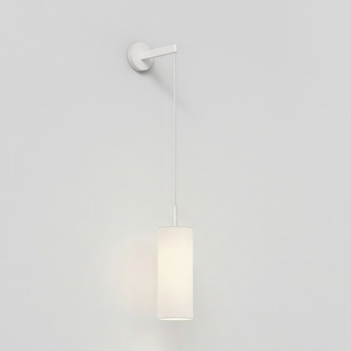 White wall-mounted light fixture with a cylindrical fabric shade