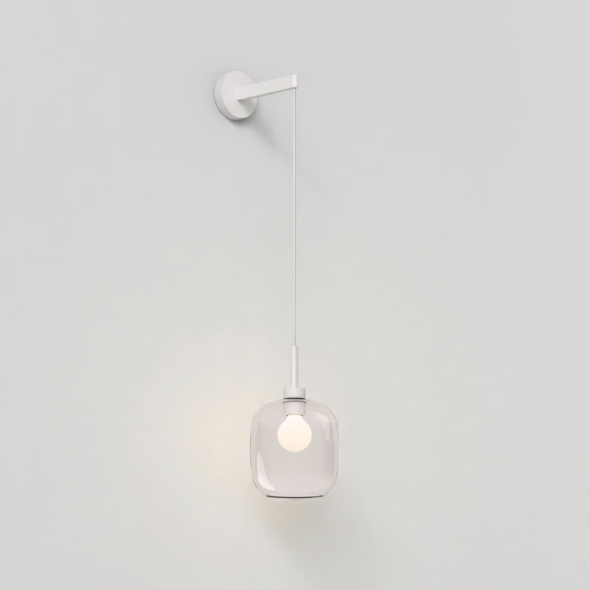 White wall lamp with a clear glass shade and a glowing bulb